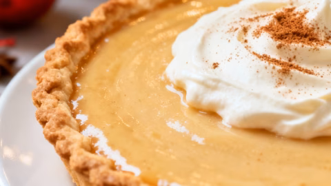 image of a top down mise en place shot showing fresh ingredients cinnamon sticks vanilla beans eggs milk sugar flour arranged on a white marble kitchen counter with healthy clear glass bowls and rustic brown wooden kitchen sets under soft diffuse daylight