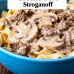 image of ground beef egg noodles mushrooms onion garlic beef broth sour cream butter olive oil flour Worcestershire sauce Dijon mustard salt black pepper fresh parsley arranged on white marble counter with clear glass bowls and rustic brown wooden kitchen sets under soft diffuse daylight