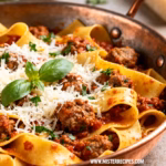 image of fresh Italian sausage pappardelle pasta canned tomatoes tomato paste olive oil onion garlic carrot celery salt black pepper red wine Parmesan cheese basil rosemary thyme bay leaves fennel seeds chili flakes chicken stock sugar butter parsley arranged on white marble counter with clear glass bowls and rustic brown wooden kitchen sets under soft diffuse daylight